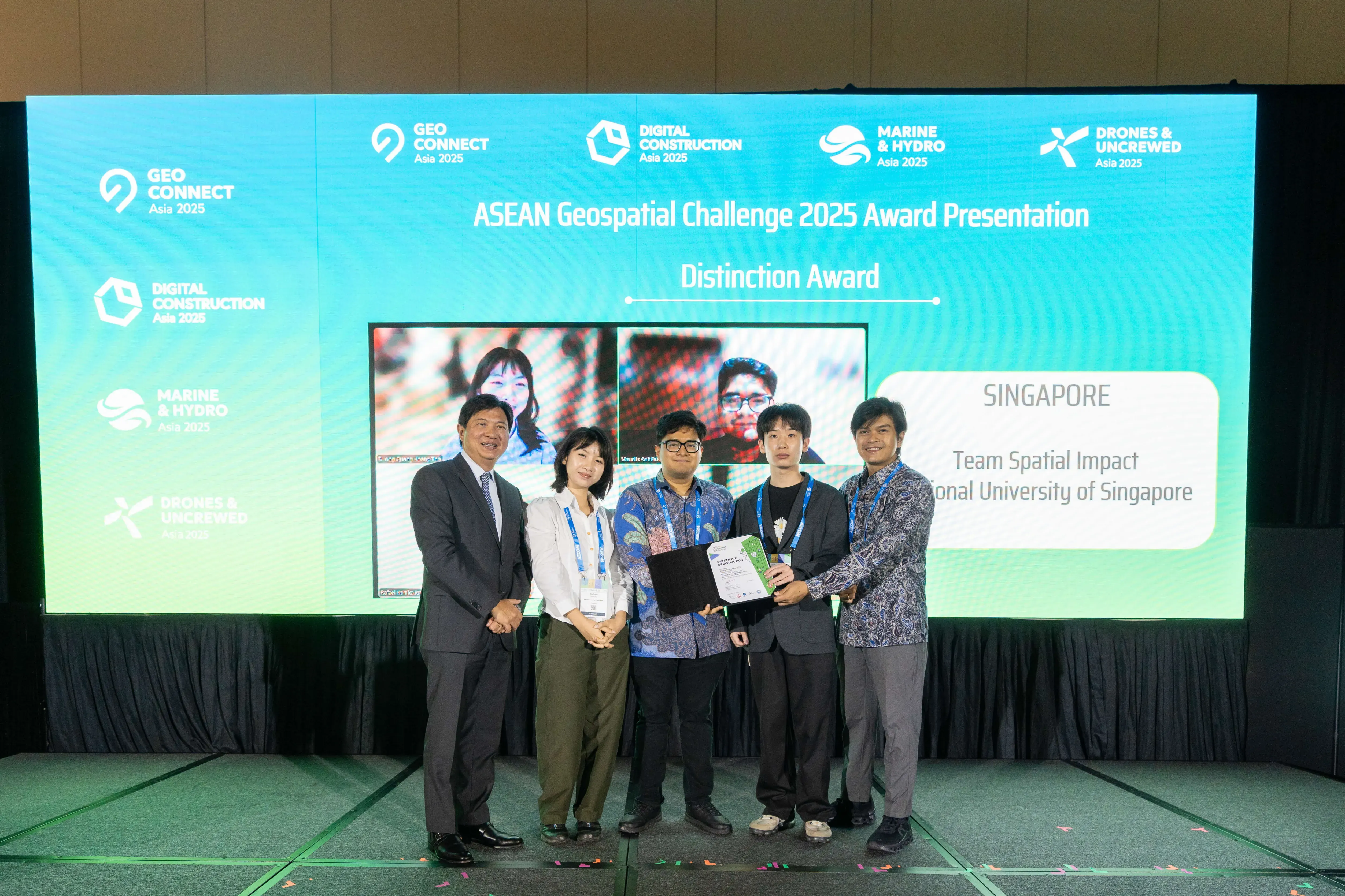 Mr Yeoh presenting a certificate to Singapore's Team Spatial Impact on stage at the ASEAN Geospatial Challenge 2025 Distinction Award presentation.